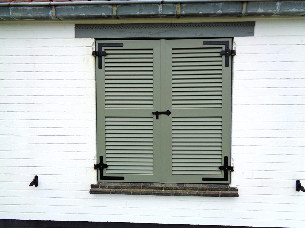 PVC raamluik met functioneel beslag gemonteerd op bestaande muurhaken – ideale oplossing voor renovatie en vervanging van oude luiken door Ventinella.