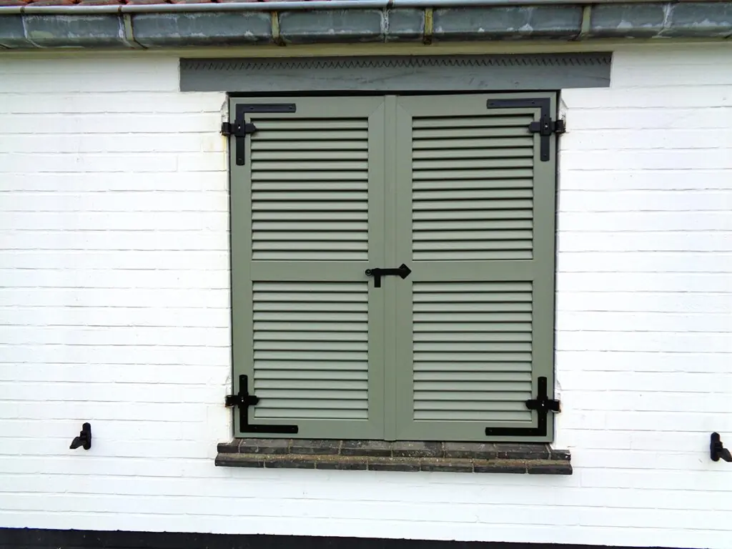 PVC raamluik met functioneel beslag gemonteerd op bestaande muurhaken – ideale oplossing voor renovatie en vervanging van oude luiken door Ventinella.