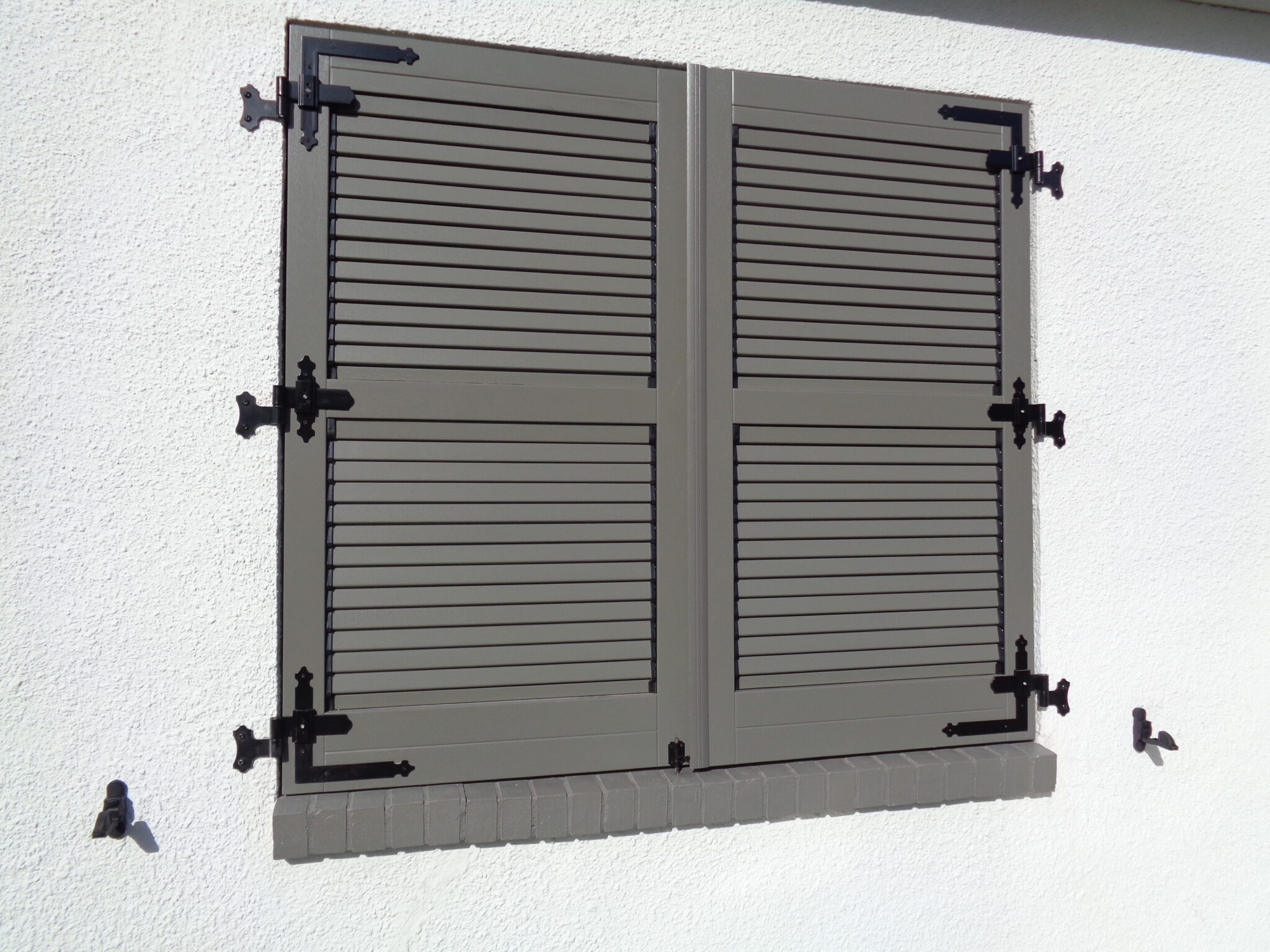 Functioneel luikbeslag voor PVC, aluminium en houten raamluiken – voorbeeld van een functioneel PVC luik met volledig beslag van Ventinella.