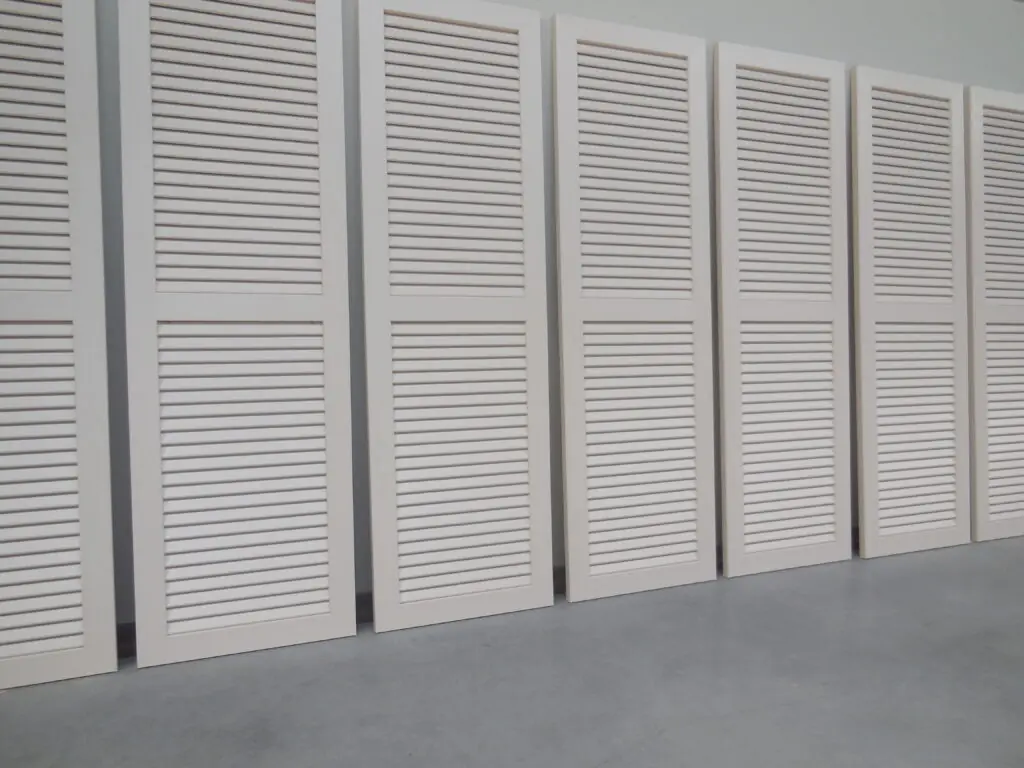 Witte PVC raamluiken model 1 open louvre met één tussenligger, op een rij geplaatst – extra stevigheid bij grotere luiken.